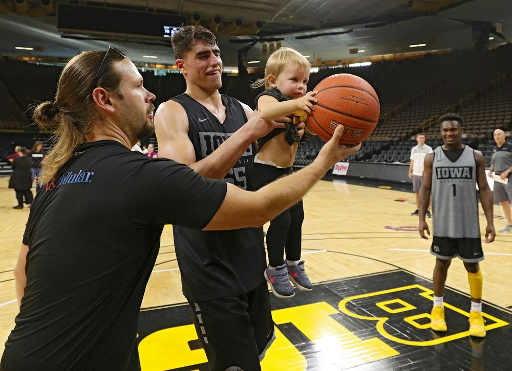 Iowa Hawkeyes center Luka Garza (55) helps a young visitor from the University of Iowa Hospitals and Clinics Adolescent and Young Adult (AYA) Cancer Program try to shoot a basket after practice at Carver-Hawkeye Arena in Iowa City on Monday, Sep 30, 2019. (Stephen Mally/hawkeyesports.com)