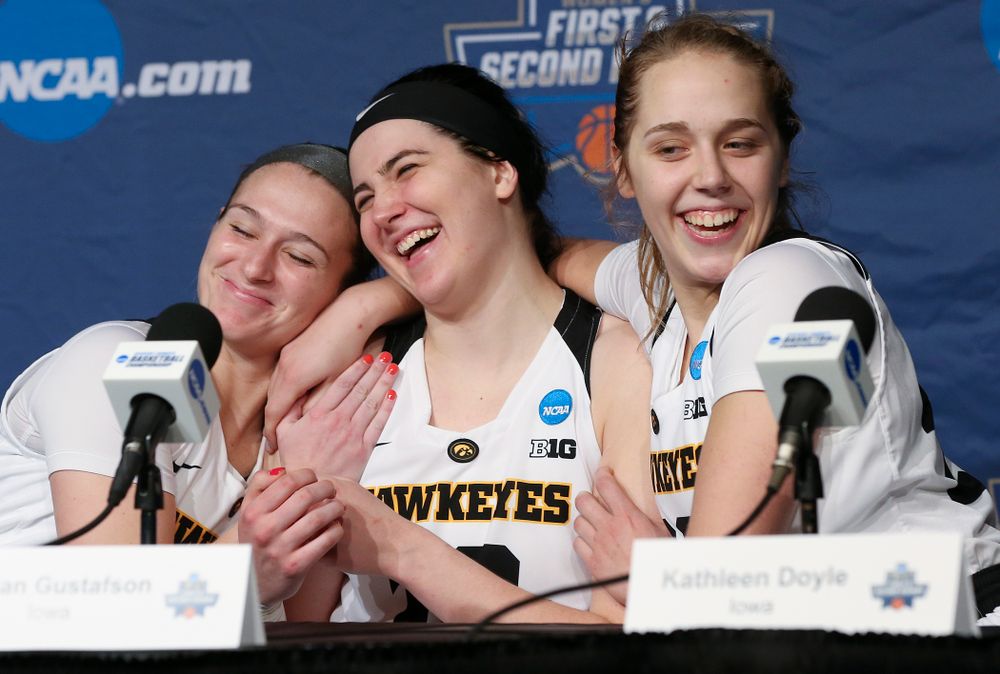 Iowa Hawkeyes guard Makenzie Meyer (left) and guard Kathleen Doyle (right) hug center Megan Gustafson (center) as she answers a question during a press conference after winning their second round game in the 2019 NCAA Women's Basketball Tournament at Carver Hawkeye Arena in Iowa City on Sunday, Mar. 24, 2019. (Stephen Mally for hawkeyesports.com)