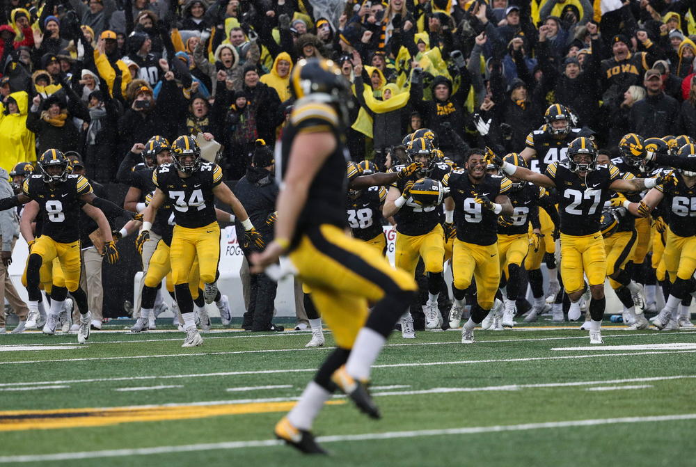 The Iowa Hawkeyes bench rushes the field after a game-winning 41-yard field goal by Iowa Hawkeyes placekicker Miguel Recinos (91) during a game against Nebraska at Kinnick Stadium on November 23, 2018. (Tork Mason/hawkeyesports.com)