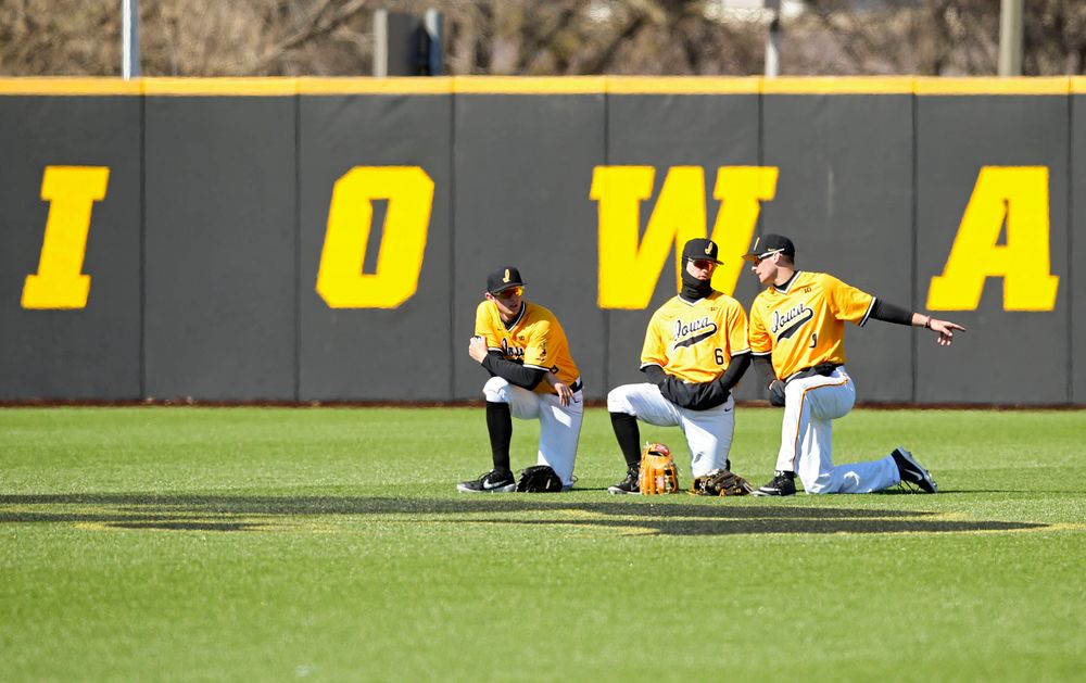 Iowa Hawkeyes outfielders Trenton Wallace (38), Justin Jenkins (6), and Ben Norman (9) talk in the outfield during a pitching change during the eighth inning against Illinois at Duane Banks Field in Iowa City on Sunday, Mar. 31, 2019. (Stephen Mally/hawkeyesports.com)
