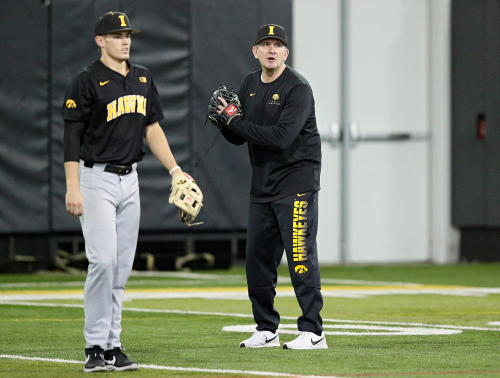 Iowa Hawkeyes head coach Rick Heller talks to his players as infielder/pitcher Dylan Nedved (17) looks on during practice at the Hansen Football Performance Center in Iowa City on Friday, January 24, 2020. (Stephen Mally/hawkeyesports.com)