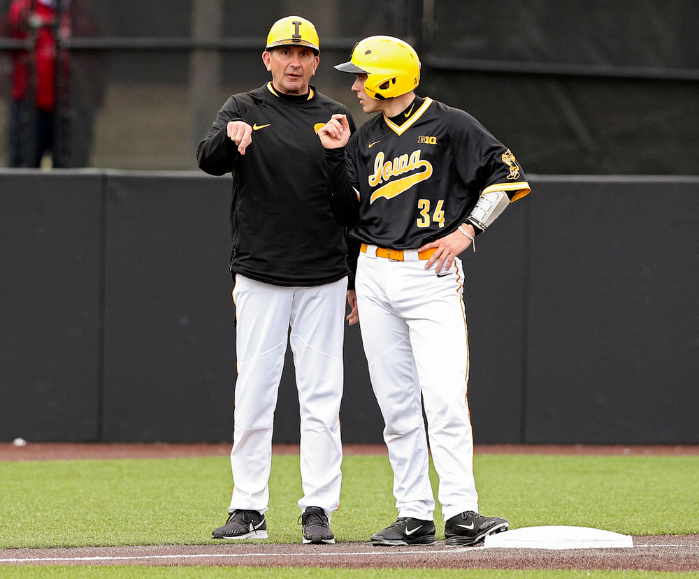Iowa Hawkeyes head coach Rick Heller talks with catcher Austin Martin (34) on third base during the third inning of their game against Illinois State at Duane Banks Field in Iowa City on Wednesday, Apr. 3, 2019. (Stephen Mally/hawkeyesports.com)