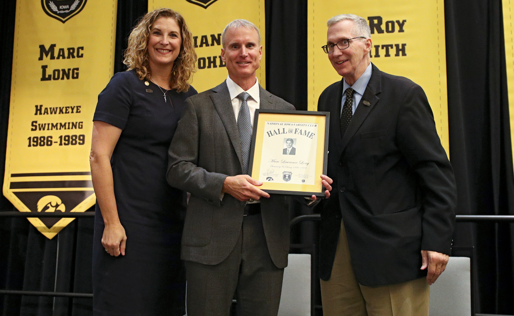 Barb Randall (from left), co-chair of the Varsity Club Advisory Committee, 2019 University of Iowa Athletics Hall of Fame inductee Marc Long, and Andy Piro, assistant athletics director and executive director of the Varsity Club, during the Hall of Fame Induction Ceremony at the Coralville Marriott Hotel and Conference Center in Coralville on Friday, Aug 30, 2019. (Stephen Mally/hawkeyesports.com)