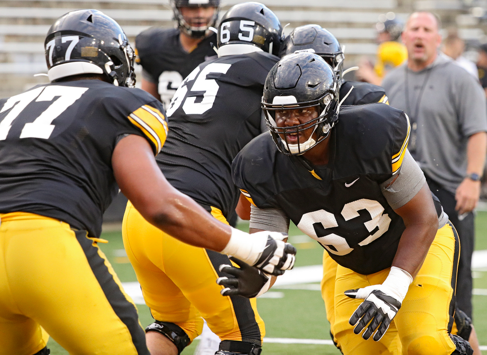 Iowa Hawkeyes offensive lineman Justin Britt (63) eyes offensive lineman Alaric Jackson (77) as they run a drill during Fall Camp Practice No. 12 at Kinnick Stadium in Iowa City on Thursday, Aug 15, 2019. (Stephen Mally/hawkeyesports.com)