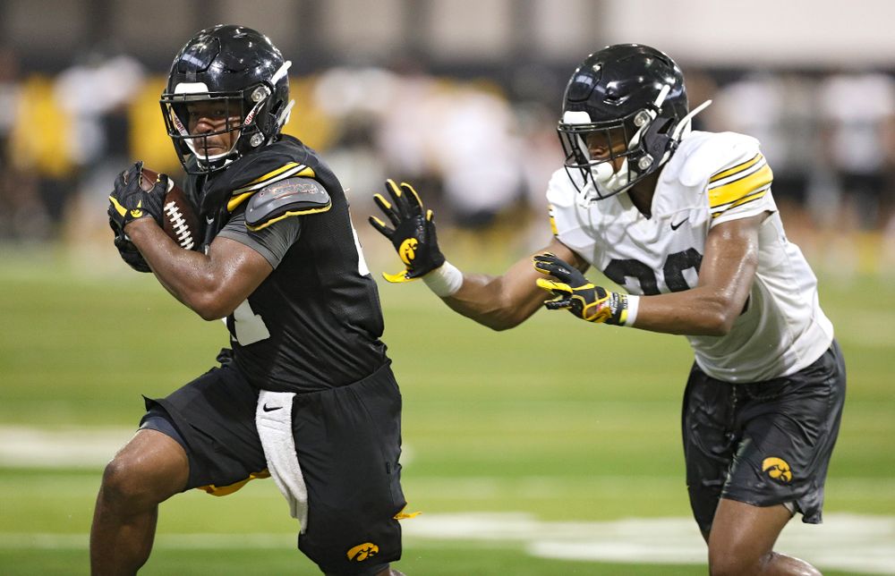 Iowa Hawkeyes running back Ivory Kelly-Martin (21) runs after pulling in a pass as defensive back Kaevon Merriweather (26) closes in during Fall Camp Practice No. 9 at the Hansen Football Performance Center in Iowa City on Monday, Aug 12, 2019. (Stephen Mally/hawkeyesports.com)