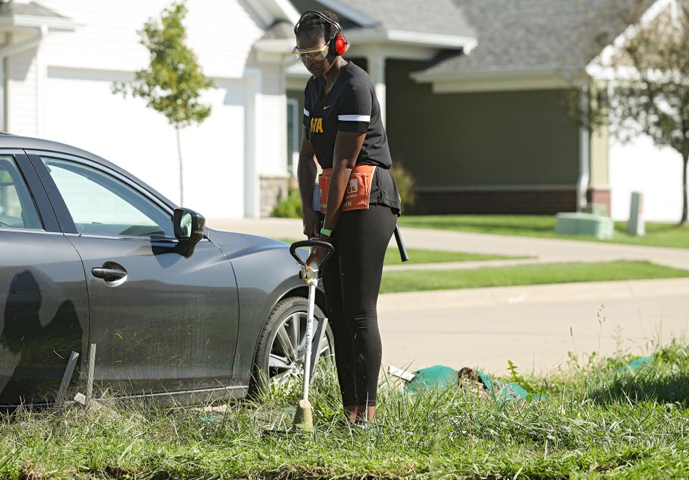 Ugo Nwaigwe, director of basketball operations, cuts down weeds with a trimmer as they work on a Habitat for Humanity Women Build project in Iowa City on Wednesday, Sep 25, 2019. (Stephen Mally/hawkeyesports.com)
