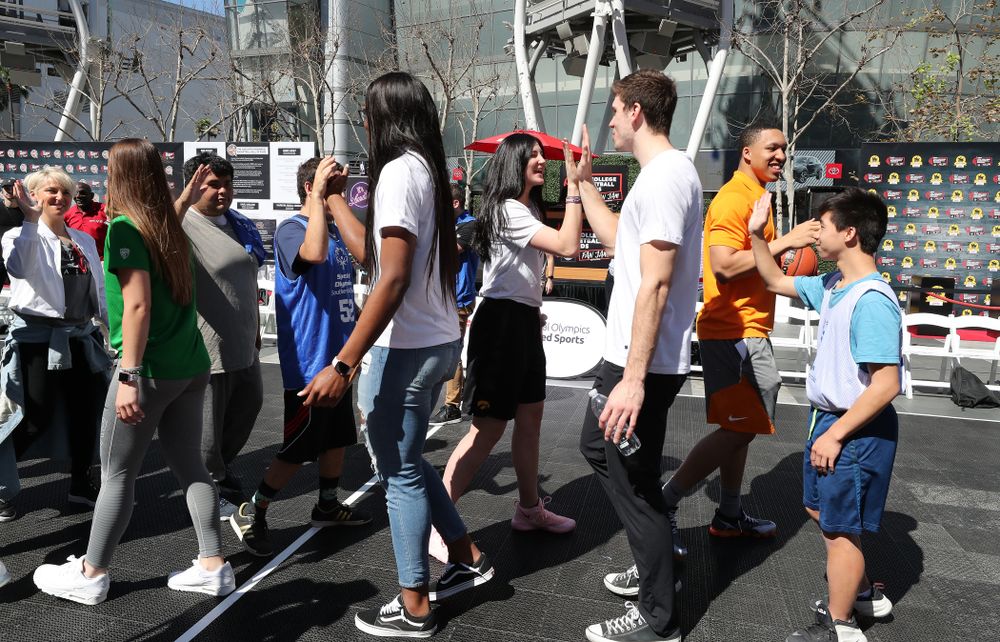 Iowa Hawkeyes forward Megan Gustafson (10) high fives WisconsinÕs Ethan Happ during a Special Olympics event Friday, April 12, 2019 as part of the ESPN College Basketball Awards in the XBOX Plaza at LA Live. (Brian Ray/hawkeyesports.com)