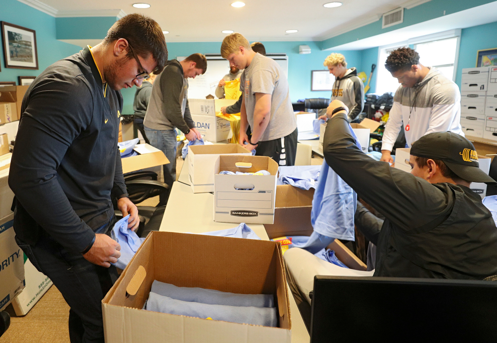 Iowa football players help fold shirts at the Ronald McDonald House for their Red Shoe Run/Walk during the 21st annual ISAAC Hawkeye Day of Caring in Iowa City on Sunday, Apr. 28, 2019. (Stephen Mally/hawkeyesports.com)
