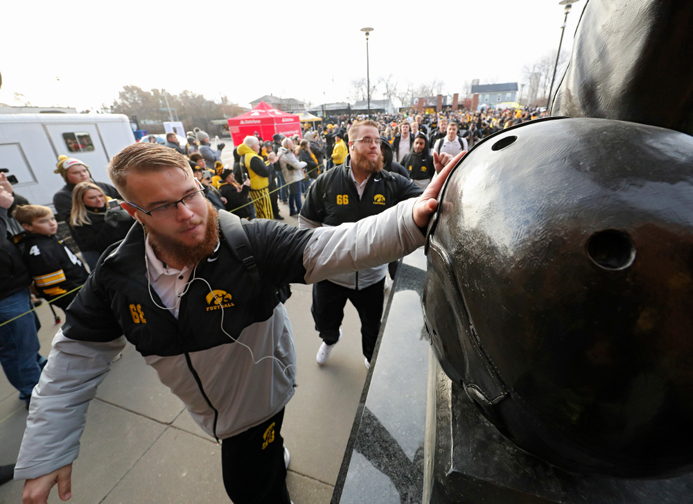 Iowa Hawkeyes offensive lineman Landan Paulsen (68) and offensive lineman Levi Paulsen (66) touch the Nile Kinnick statue before their game at Kinnick Stadium in Iowa City on Saturday, Nov 23, 2019. (Stephen Mally/hawkeyesports.com)
