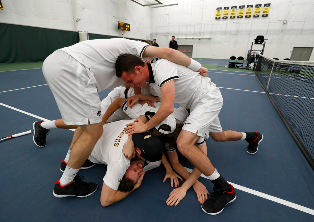 Iowa's Piotr Smietana celebrates with his teammates after clinching the match against Purdue Sunday, April 15, 2018 at the Hawkeye Tennis an