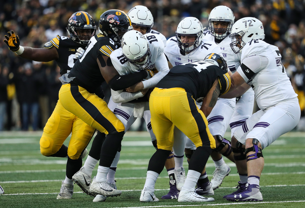 Iowa Hawkeyes defensive end Chauncey Golston (57) and Iowa Hawkeyes defensive end A.J. Epenesa (94) sack the quarterback during a game against Northwestern at Kinnick Stadium on November 10, 2018. (Tork Mason/hawkeyesports.com)
