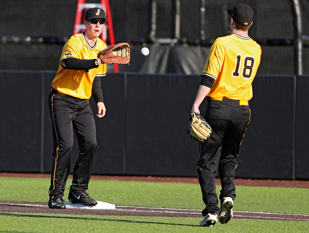 Iowa Hawkeyes first baseman Connor McCaffery (30) pulls in a toss from pitcher Shane Ritter (18) for an out during the sixth inning of their game at Duane Banks Field in Iowa City on Tuesday, Apr. 2, 2019. (Stephen Mally/hawkeyesports.com)