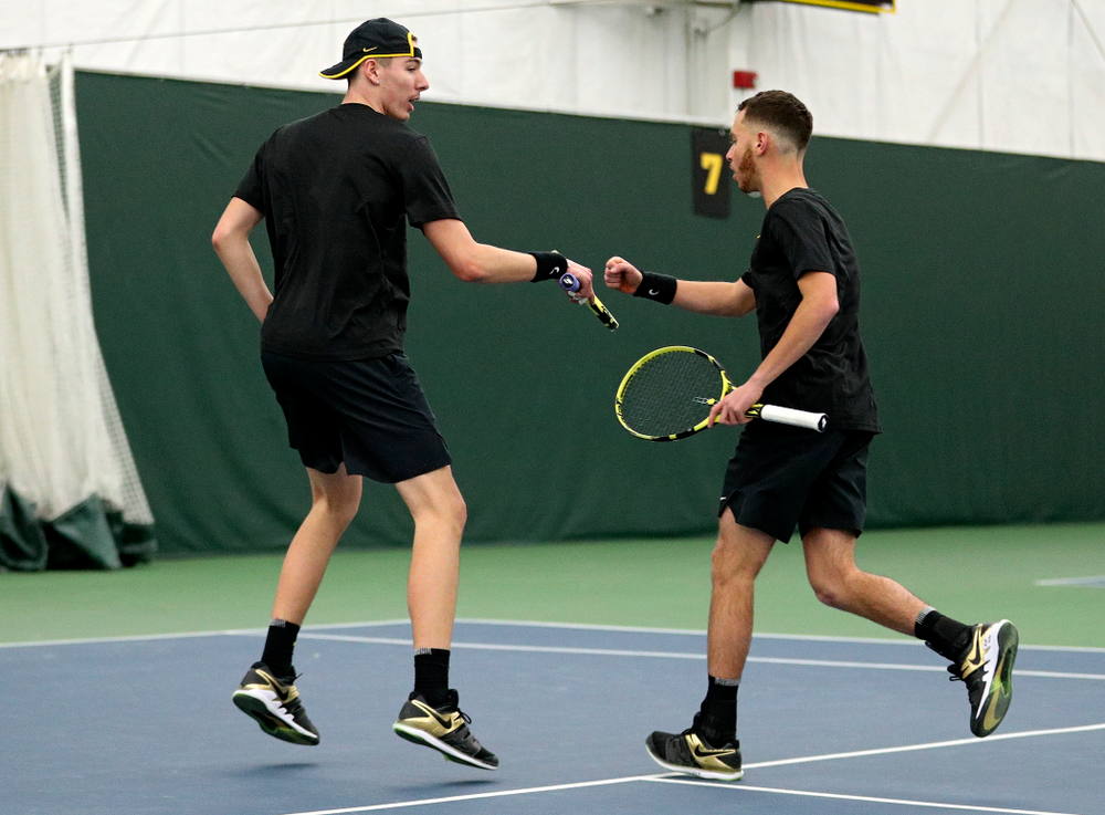 Iowa’s Nikita Snezhko (from left) and Kareem Allaf fist bump as they celebrate during their doubles match at the Hawkeye Tennis and Recreation Complex in Iowa City on Friday, February 14, 2020. (Stephen Mally/hawkeyesports.com)