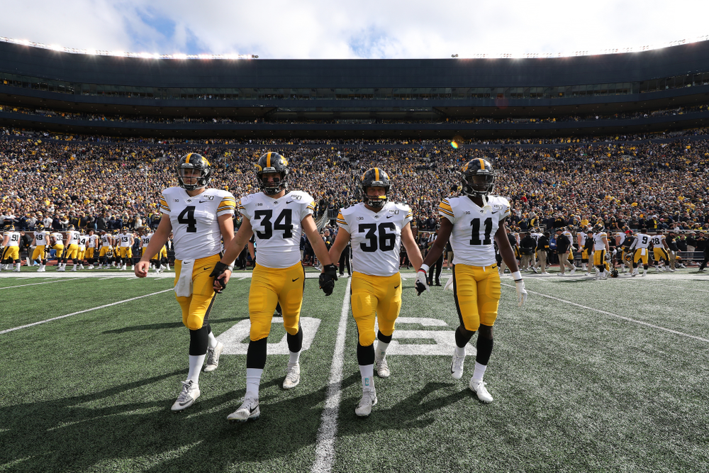 Iowa Hawkeyes quarterback Nate Stanley (4), linebacker Kristian Welch (34), fullback Brady Ross (36), and defensive back Michael Ojemudia (11) against the Michigan Wolverines Saturday, October 5, 2019 at Michigan Stadium in Ann Arbor, MI. (Brian Ray/hawkeyesports.com)