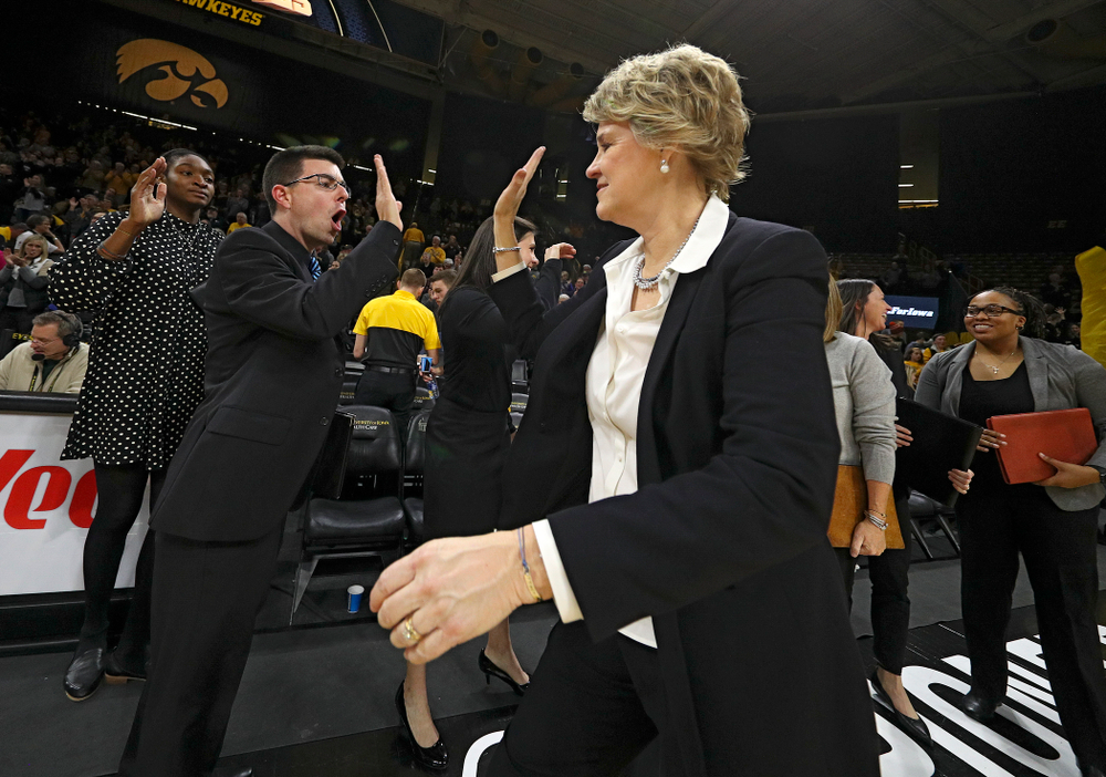 Iowa Hawkeyes head coach Lisa Bluder (right) gets a high-five from Ryan Gruebel, video coordinator and creative director, after winning their game at Carver-Hawkeye Arena in Iowa City on Thursday, January 23, 2020. (Stephen Mally/hawkeyesports.com)