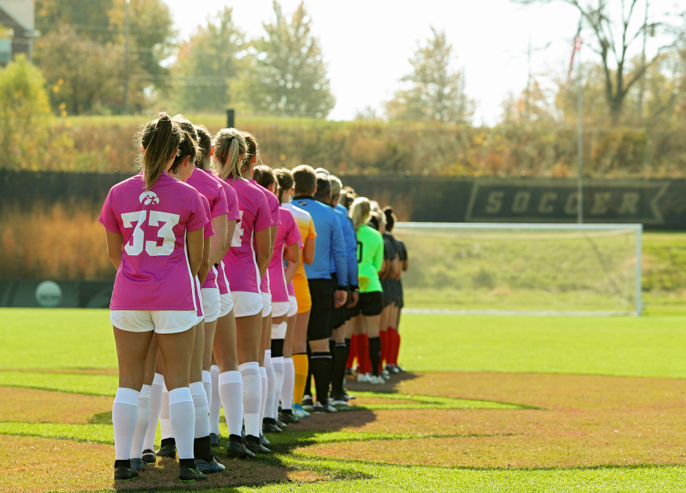 Iowa defender Riley Burns (33), forward Devin Burns (30), forward Samantha Tawharu (27), midfielder Josie Durr (25), defender Sara Wheaton (24), defender Hannah Drkulec (17), midfielder/defender Natalie Winters (10), defender Samantha Cary (9), midfielder Isabella Blackman (6), defender Riley Whitaker (5), and goalkeeper Claire Graves (1) stand for the National Anthem before their match at the Iowa Soccer Complex in Iowa City on Sunday, Oct 27, 2019. (Stephen Mally/hawkeyesports.com)