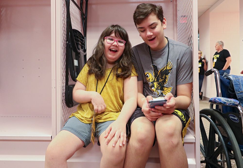 Kid Captain Lucy Roth sits in a locker in the visitor’s pink locker room during Kids Day at Kinnick Stadium in Iowa City on Saturday, Aug 10, 2019. (Stephen Mally/hawkeyesports.com)