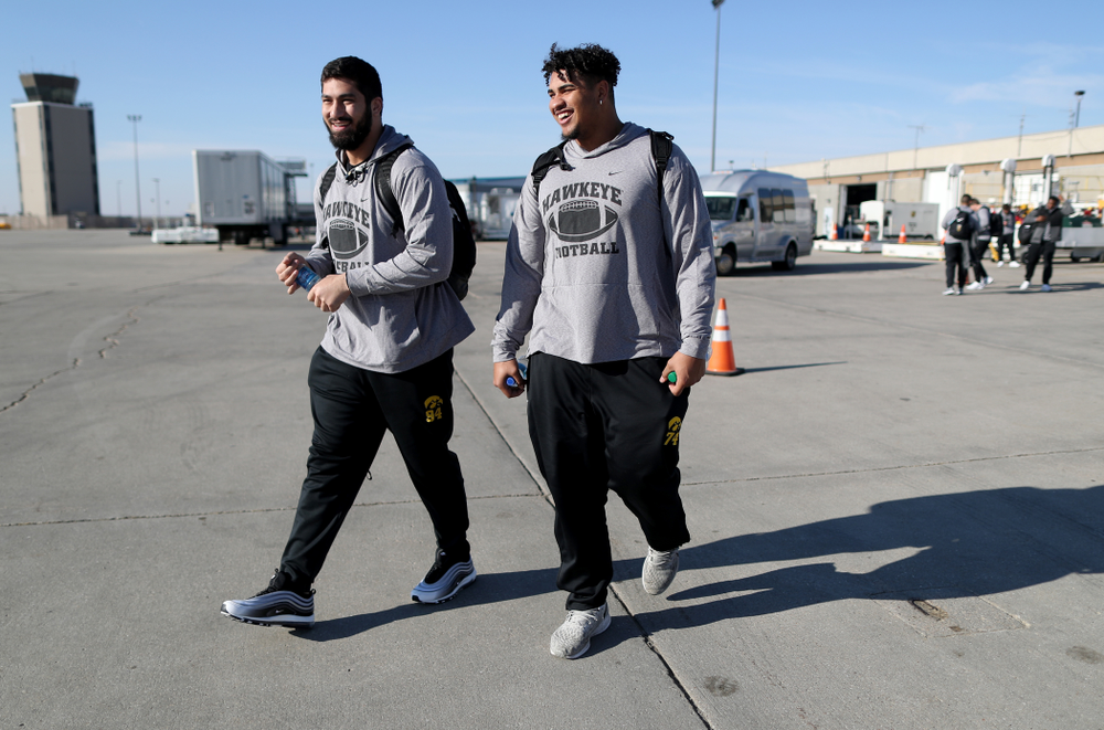 Iowa Hawkeyes defensive end A.J. Epenesa (94) and offensive lineman Tristan Wirfs (74) board the team plane at the Eastern Iowa Airport Saturday, December 21, 2019 on the way to San Diego, CA for the Holiday Bowl. (Brian Ray/hawkeyesports.com)