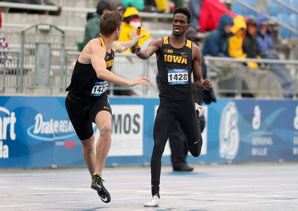 Iowa's Wayne Lawrence Jr. (right) hands off the baton to Noah Larrison as they run the men's 1600 meter relay event during the third day of the Drake Relays at Drake Stadium in Des Moines on Saturday, Apr. 27, 2019. (Stephen Mally/hawkeyesports.com)