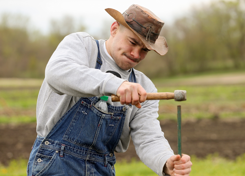 Iowa wrestlers work in the field for Grow: Johnson County at the Johnson County Historic Poor Farm during the 21st annual ISAAC Hawkeye Day of Caring in Iowa City on Sunday, Apr. 28, 2019. (Stephen Mally/hawkeyesports.com)