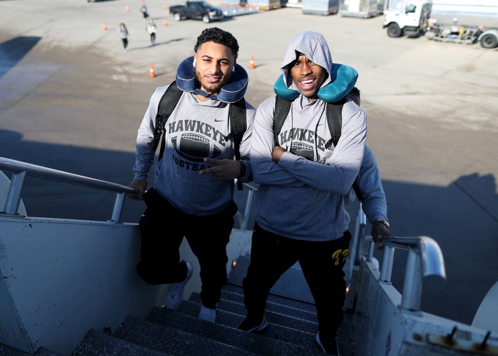 Iowa Hawkeyes defensive back Geno Stone (9) and defensive back Michael Ojemudia (11) board the team plane at the Eastern Iowa Airport Saturday, December 21, 2019 on the way to San Diego, CA for the Holiday Bowl. (Brian Ray/hawkeyesports.com)