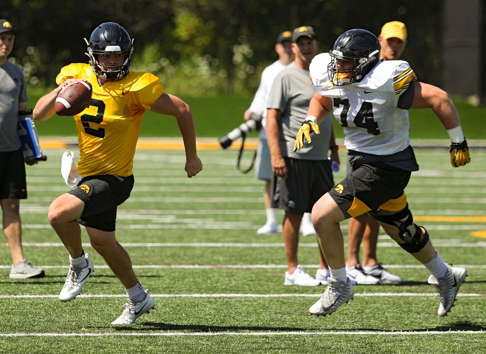 Iowa Hawkeyes quarterback Peyton Mansell (2) tries to avoid defensive lineman Austin Schulte (74) during Fall Camp Practice No. 7 at the Hansen Football Performance Center in Iowa City on Friday, Aug 9, 2019. (Stephen Mally/hawkeyesports.com)