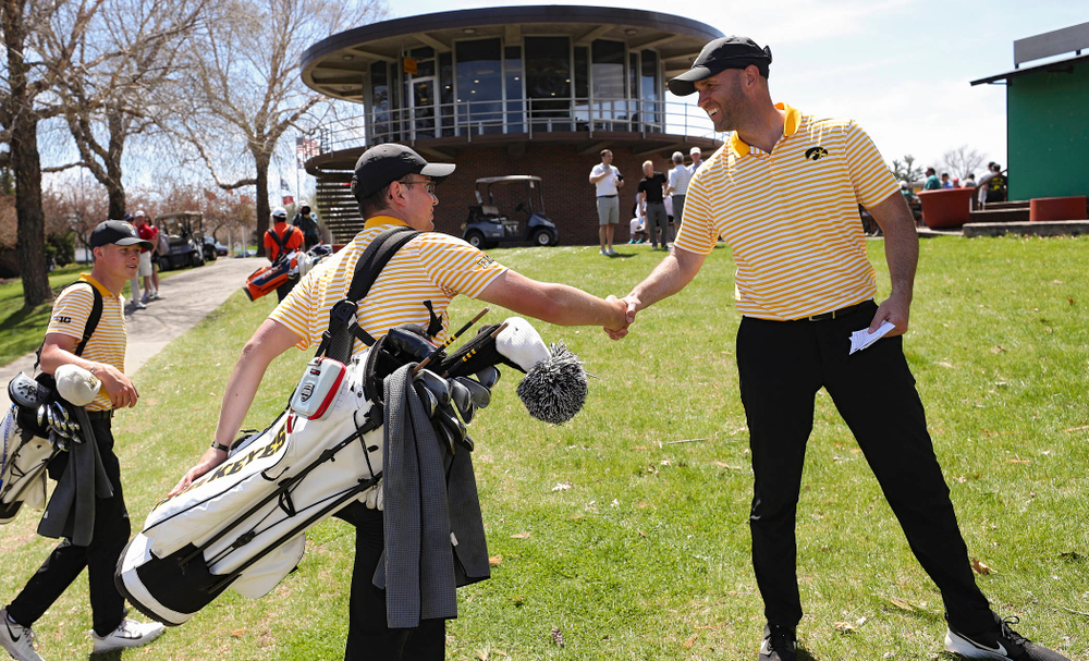 Iowa's Matthew Walker (from left) shakes hands with head coach Tyler Stith after finishing his round during the third round of the Hawkeye Invitational at Finkbine Golf Course in Iowa City on Sunday, Apr. 21, 2019. (Stephen Mally/hawkeyesports.com)