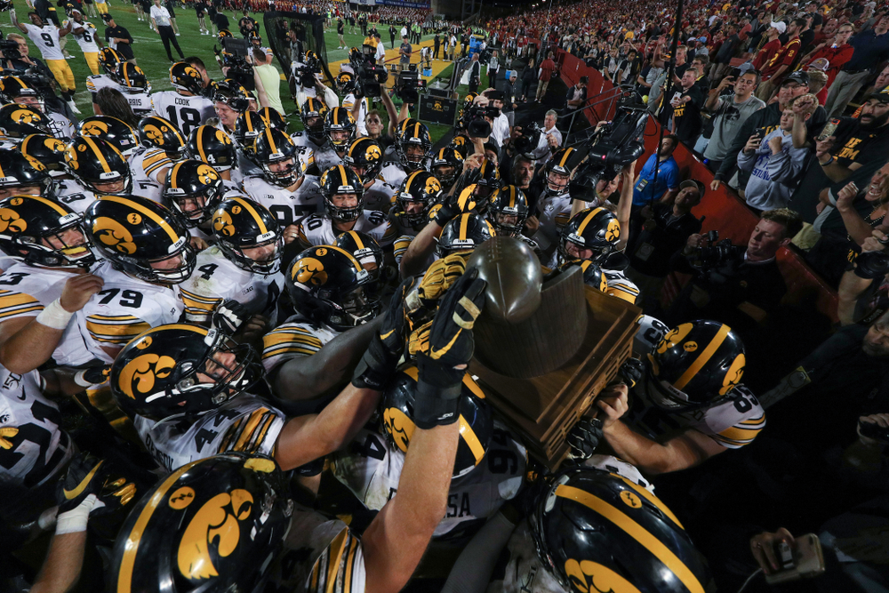 The Iowa Hawkeyes swarm to the Cy-Hawk trophy following their game against the Iowa State Cyclones Saturday, September 14, 2019 in Ames, Iowa. (Brian Ray/hawkeyesports.com)