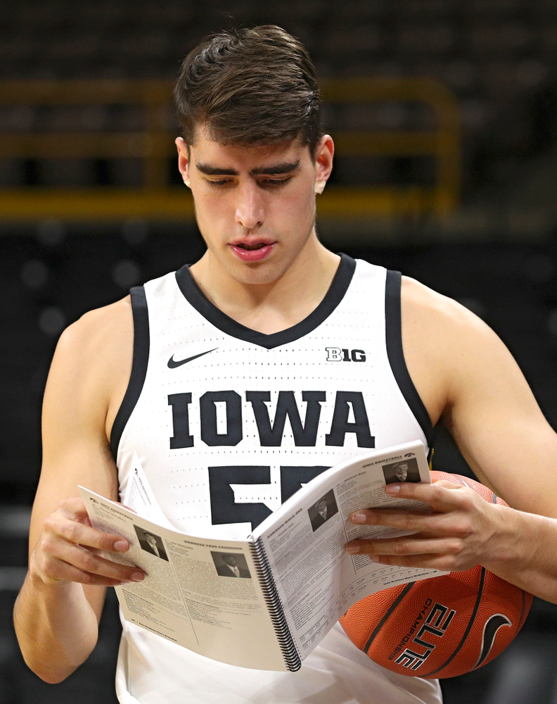 Iowa Hawkeyes forward Luka Garza (55) reads a media guide during Iowa Men’s Basketball Media Day at Carver-Hawkeye Arena in Iowa City on Wednesday, Oct 9, 2019. (Stephen Mally/hawkeyesports.com)
