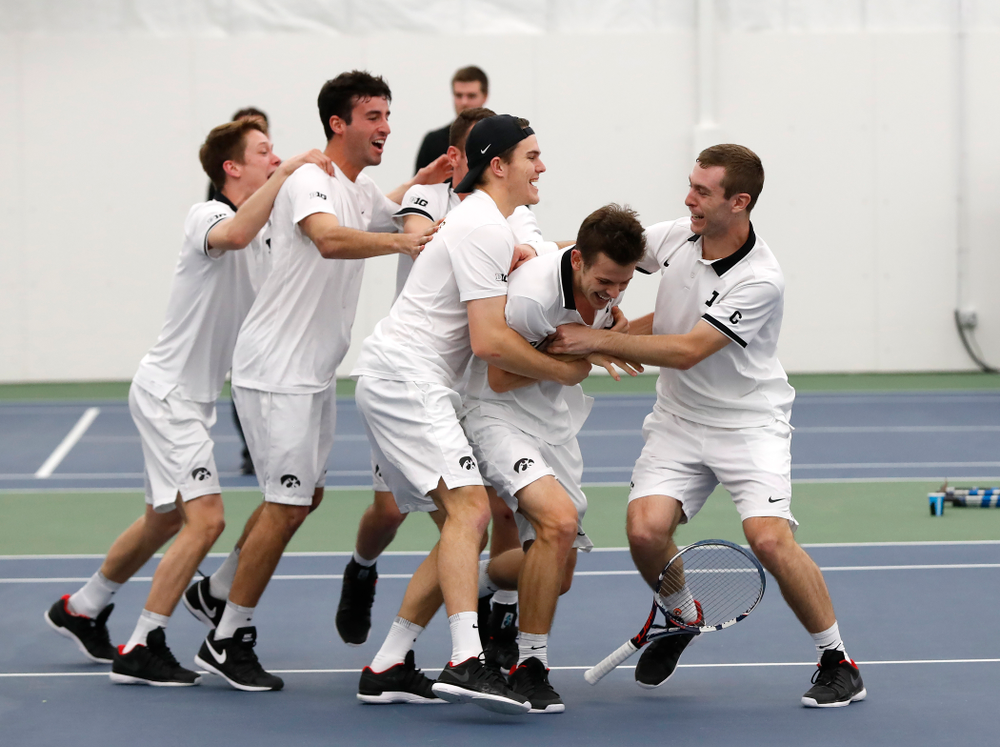 Iowa's Piotr Smietana celebrates with his teammates after clinching the match against Purdue Sunday, April 15, 2018 at the Hawkeye Tennis an