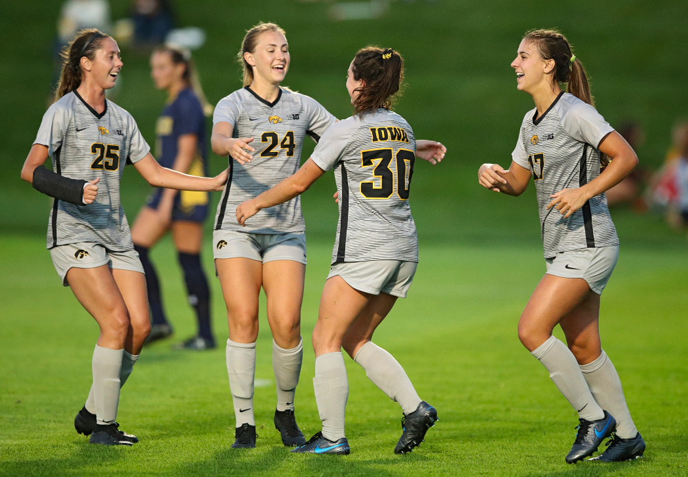 Iowa midfielder Josie Durr (25), defender Sara Wheaton (24), and defender Hannah Drkulec (17) celebrate with forward Devin Burns (30) after Burns scored a goal during the first half of their match at the Iowa Soccer Complex in Iowa City on Friday, Sep 13, 2019. (Stephen Mally/hawkeyesports.com)