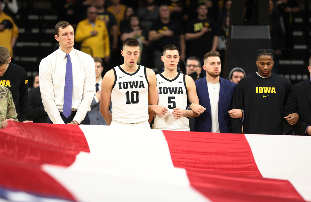 Iowa Hawkeyes forward Jack Nunge (2), guard Joe Wieskamp (10), guard CJ Fredrick (5), guard Jordan Bohannon (3), and guard Bakari Evelyn (4) as members of the Iowa Army ROTC display a large American flag before their game against Penn State Saturday, February 29, 2020 at Carver-Hawkeye Arena. (Brian Ray/hawkeyesports.com)