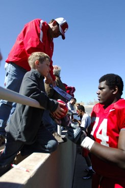 Sophomore Byron Bell signs a young boys football after the Cherry-Silver game Saturday.
