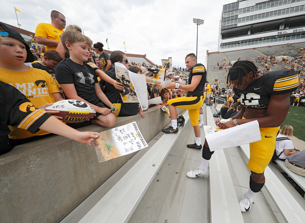 Iowa Hawkeyes wide receiver Brandon Smith (12) signs an autograph during Kids Day at Kinnick Stadium in Iowa City on Saturday, Aug 10, 2019. (Stephen Mally/hawkeyesports.com)