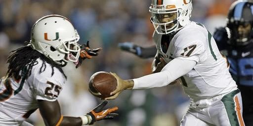 Miami quarterback Stephen Morris (17) hands off to Dallas Crawford (25) during the first half of an NCAA college football game against North Carolina...