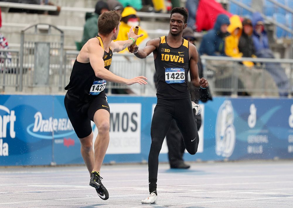 Iowa's Wayne Lawrence Jr. (right) hands off the baton to Noah Larrison as they run the men's 1600 meter relay event during the third day of the Drake Relays at Drake Stadium in Des Moines on Saturday, Apr. 27, 2019. (Stephen Mally/hawkeyesports.com)