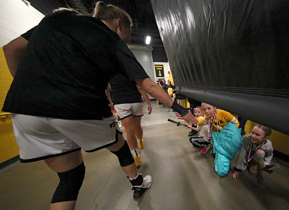 Young fans give Iowa Hawkeyes forward Monika Czinano (25) a high-five as she walks to the court before the start of their game at Carver-Hawkeye Arena in Iowa City on Sunday, January 26, 2020. (Stephen Mally/hawkeyesports.com)