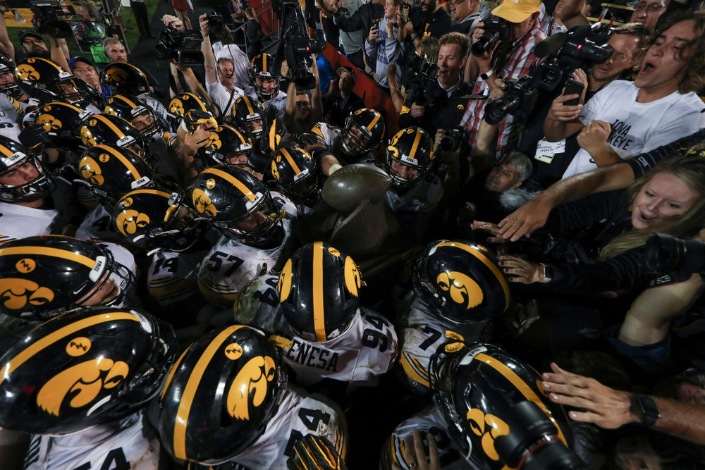 The Iowa Hawkeyes swarm to the Cy-Hawk trophy following their game against the Iowa State Cyclones Saturday, September 14, 2019 in Ames, Iowa. (Brian Ray/hawkeyesports.com)