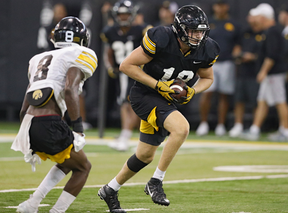 Iowa Hawkeyes tight end Drew Cook (18) pulls in a pass as defensive back Matt Hankins (8) closes in during Fall Camp Practice No. 9 at the Hansen Football Performance Center in Iowa City on Monday, Aug 12, 2019. (Stephen Mally/hawkeyesports.com)