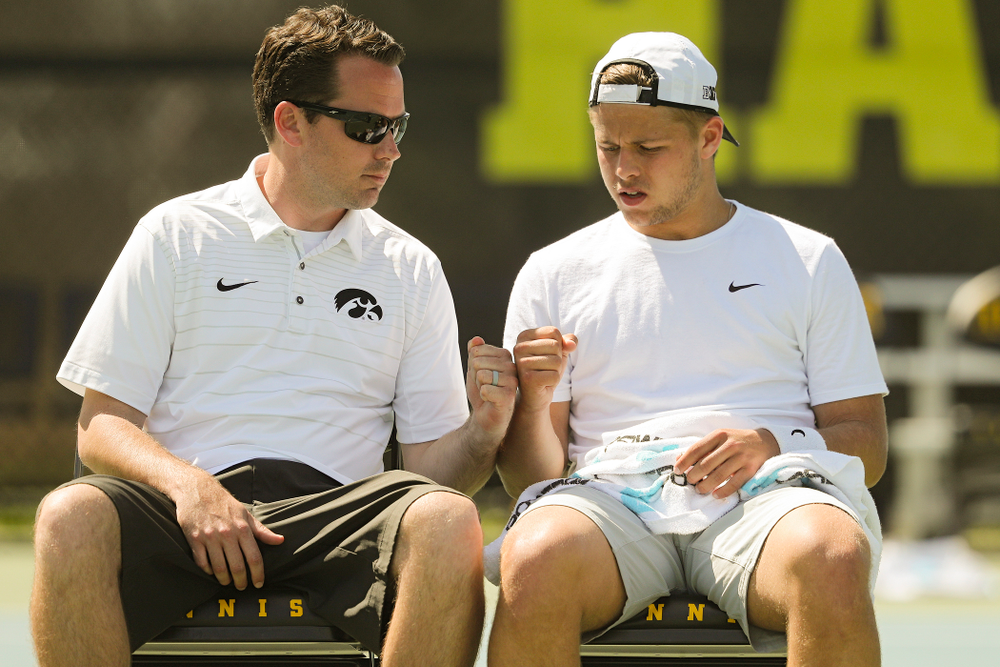 Iowa head coach Ross Wilson (from left) fist bumps Will Davies during his match against Michigan at the Hawkeye Tennis and Recreation Complex in Iowa City on Sunday, Apr. 21, 2019. (Stephen Mally/hawkeyesports.com)
