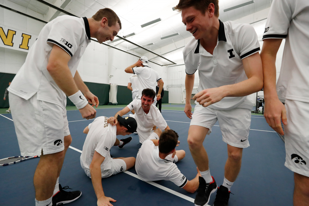 Iowa's Piotr Smietana celebrates with his teammates after clinching the match against Purdue Sunday, April 15, 2018 at the Hawkeye Tennis an