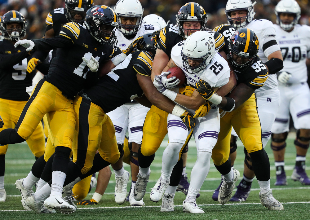 Iowa Hawkeyes linebacker Djimon Colbert (32), Iowa Hawkeyes defensive lineman Brady Reiff (91) and Iowa Hawkeyes defensive lineman Cedrick Lattimore (95) make a tackle during a game against Northwestern at Kinnick Stadium on November 10, 2018. (Tork Mason/hawkeyesports.com)