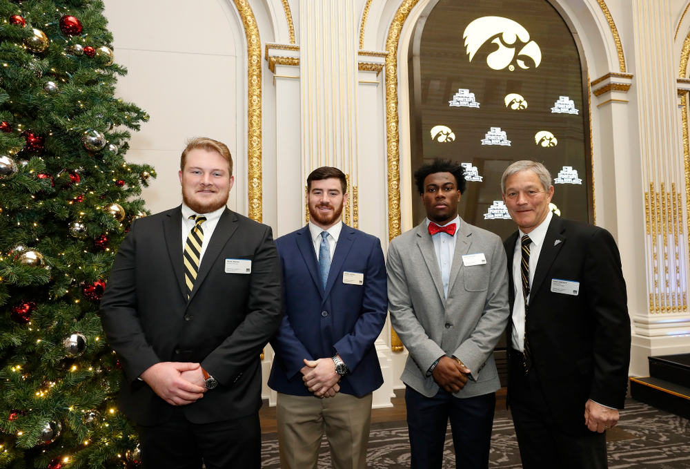 Iowa Hawkeyes linebacker Josey Jewell (43), defensive back Joshua Jackson (15), offensive lineman Sean Welsh (79) and head coach Kirk Ferentz ring the opening bell at the New York Stock Exchange Tuesday, December 26, 2017 in New York. (Brian Ray/hawkeyesports.com)