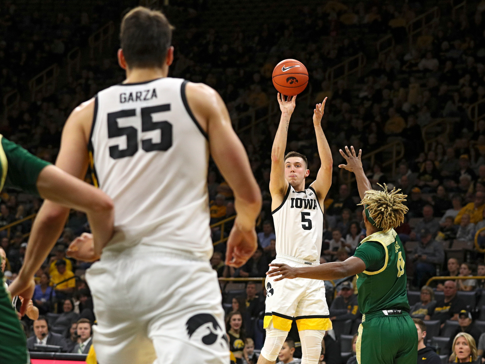 Iowa Hawkeyes guard CJ Fredrick (5) makes a 3-pointer as center Luka Garza (55) looks on during the first half of their game at Carver-Hawkeye Arena in Iowa City on Sunday, Nov 24, 2019. (Stephen Mally/hawkeyesports.com)