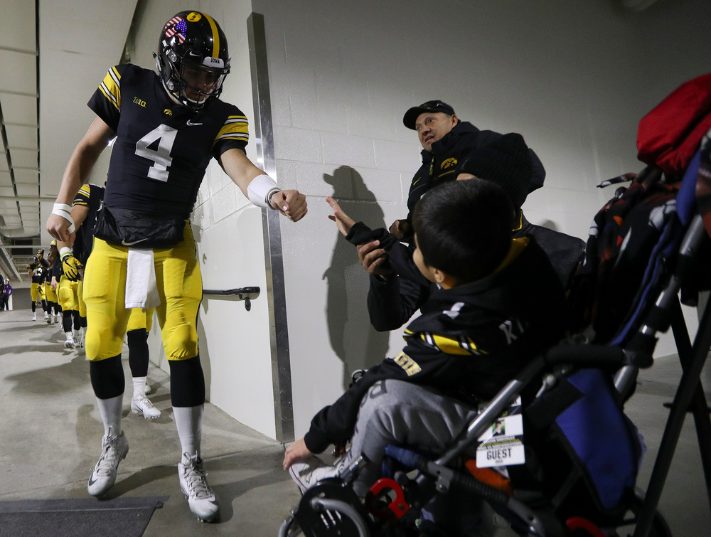 Iowa Hawkeyes quarterback Nate Stanley (4) fist bumps Kid Captain Mason Gonzalez before a game against Northwestern at Kinnick Stadium on November 10, 2018. (Tork Mason/hawkeyesports.com)