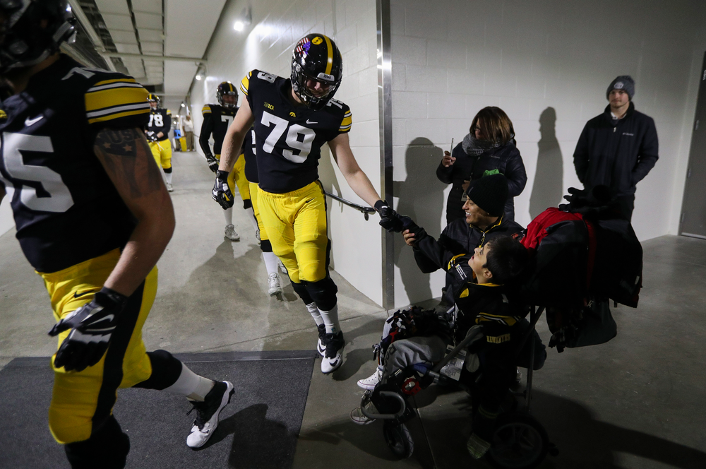Iowa Hawkeyes offensive lineman Jack Plumb (79) fist bumps with Kid Captain Mason Gonzalez before a game against Northwestern at Kinnick Stadium on November 10, 2018. (Tork Mason/hawkeyesports.com)