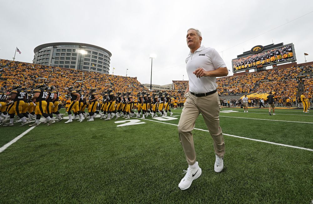 Iowa Hawkeyes head coach Kirk Ferentz runs onto the field as the Hawkeyes swarm as they take the field before their game at Kinnick Stadium in Iowa City on Saturday, Sep 28, 2019. (Stephen Mally/hawkeyesports.com)