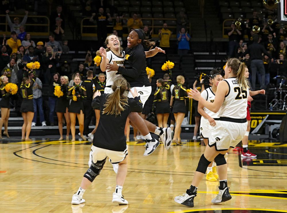 Iowa Hawkeyes guard Kathleen Doyle (22), guard Zion Sanders (21), and guard Kate Martin (20) celebrate after their double overtime win at Carver-Hawkeye Arena in Iowa City on Sunday, January 12, 2020. (Stephen Mally/hawkeyesports.com)