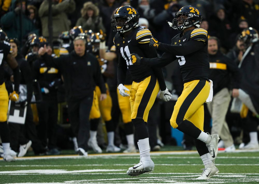 Iowa Hawkeyes defensive back Michael Ojemudia (11) and Iowa Hawkeyes defensive back Geno Stone (9) react after Stone's interception during a game against Northwestern at Kinnick Stadium on November 10, 2018. (Tork Mason/hawkeyesports.com)