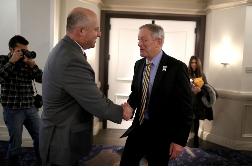 Iowa Hawkeyes head coach Kirk Ferentz shakes hands with USC head coach Clay Helton during a press conference leading up to the Holiday Bowl Thursday, December 26, 2019 in San Diego. (Brian Ray/hawkeyesports.com)